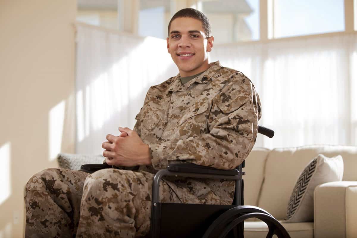A veteran in uniform sitting in a chair.