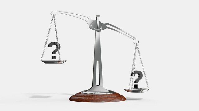 A balance scale with question marks symbolizing uncertainty during the Social Security Claim filing process.